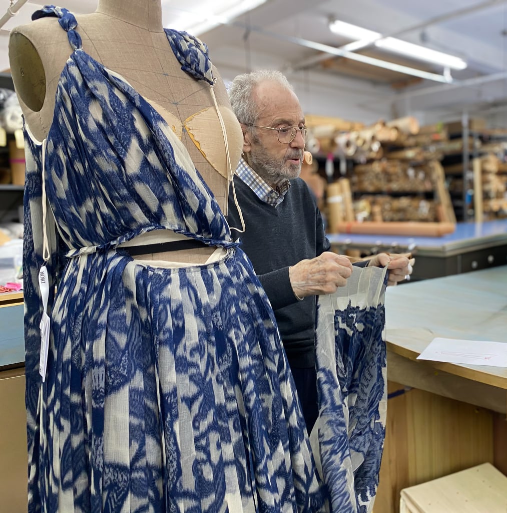 My father Leon standing next to a Dior gown that is partially disassembled being repaired.